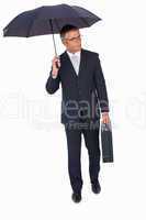 Businessman holding briefcase and standing under umbrella