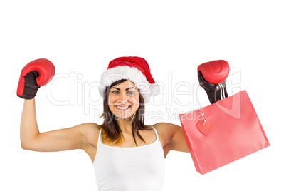 Festive brunette in boxing gloves holding shopping bags