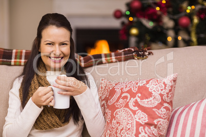 Smiling brunette enjoying hot chocolate