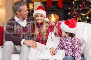 Portrait of a smiling family sitting on sofa at christmas time