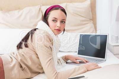 Pretty brunette using laptop on bed Pretty brunette using laptop on bed