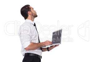 Sophisticated businessman standing using a laptop