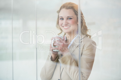 Businesswoman holding cup of coffee through the window