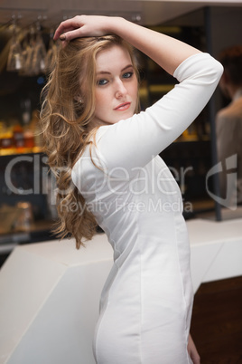 Pretty blonde girl in white dress posing hands in the hair