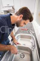 Plumber fixing sink with screwdriver