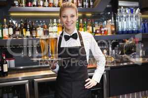 Waitress with hand on hip holding a tray of champagne