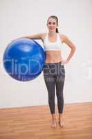 Fit brunette holding exercise ball