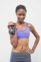 Fit woman smiling at camera holding kettlebell