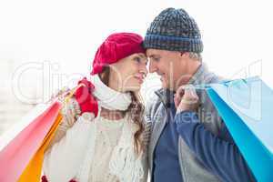 Happy couple in warm clothing with shopping bags