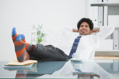 Businessman relaxing in his swivel chair with feet up