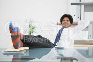 Businessman relaxing in his swivel chair with feet up