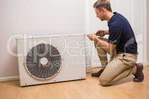 Focused handyman fixing air conditioning