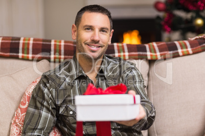 Smiling man offering gift on christmas day