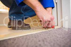 Handyman laying down a carpet