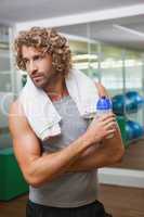 Handsome man holding water bottle at gym