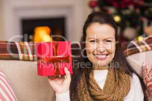 Pretty brunette woman showing christmas gift