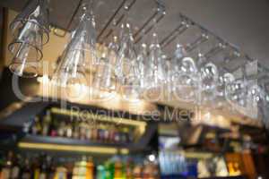 Many wine glasses hanging above the bar