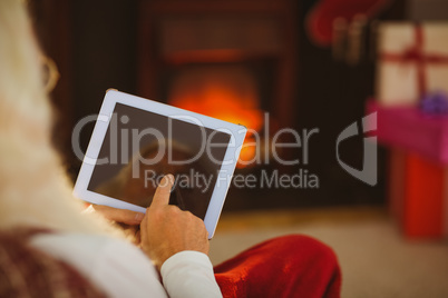 Santa claus touching digital tablet