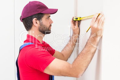 Construction worker using measuring tape