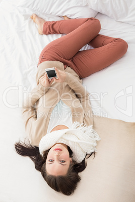 Pretty brunette sending a text on bed Pretty brunette sending a text on bed