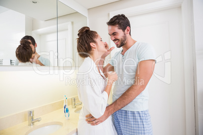 Young man putting cream on girlfriends nose