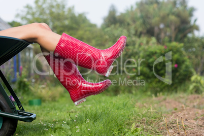 Woman in welly boots in wheelbarrow