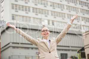 Young businesswoman with her arms up