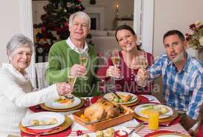 Happy family toasting at camera during christmas dinner