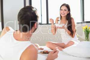 Young couple having breakfast in bed