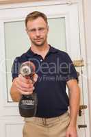 Handyman pointing power tool at camera