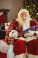 Happy santa holding glasses and tablet