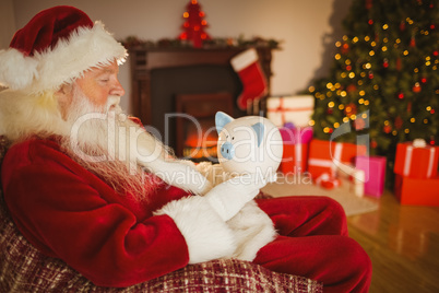 Father christmas holding piggy bank