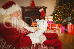 Father christmas holding piggy bank