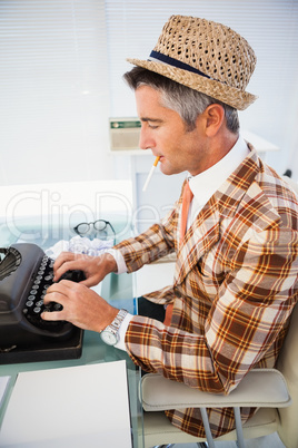 Vintage man in straw hat typing on typewriter