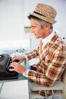 Vintage man in straw hat typing on typewriter