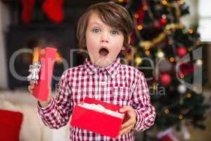 Surprised little boy holding a gift