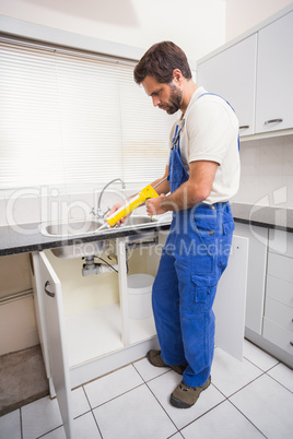 Plumber putting filling in between tiles