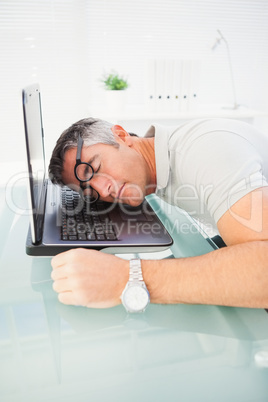 Man with glasses sleeping on his laptop