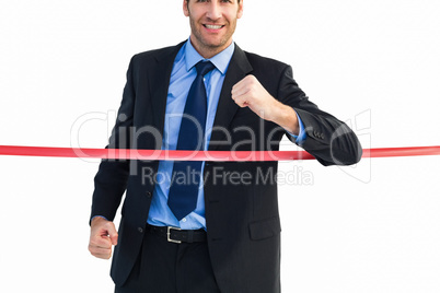 Happy businessman crossing finishing line