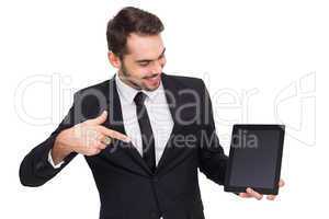 Happy businessman pointing with his tablet