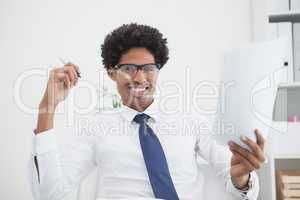 Smiling businessman holding paper and pen