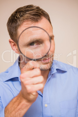 Man looking through magnifying glass