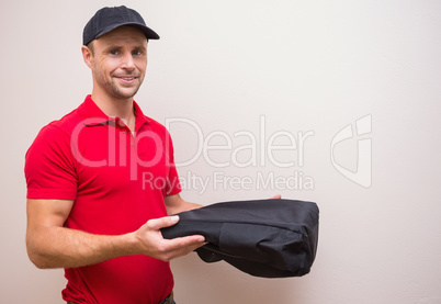 Portrait of delivery man holding pizza in thermal bag