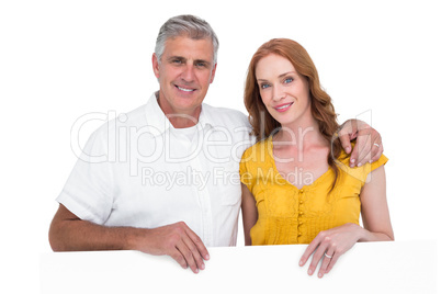 Casual couple showing a poster