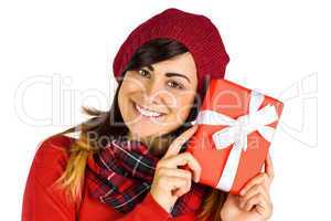 Smiling brunette in red hat holding gift