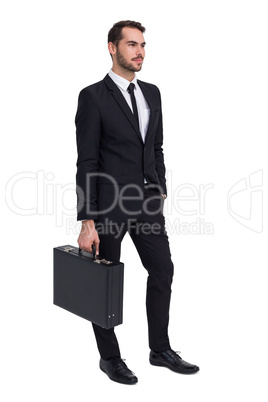 Cheerful businessman holding briefcase while hand in pocket