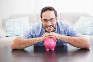 Smiling man laying on the piggy bank