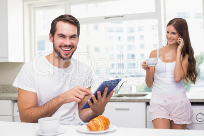 Young man using tablet pc at breakfast