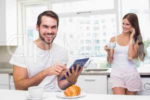 Young man using tablet pc at breakfast