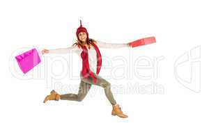 Happy brunette jumping with gifts bags